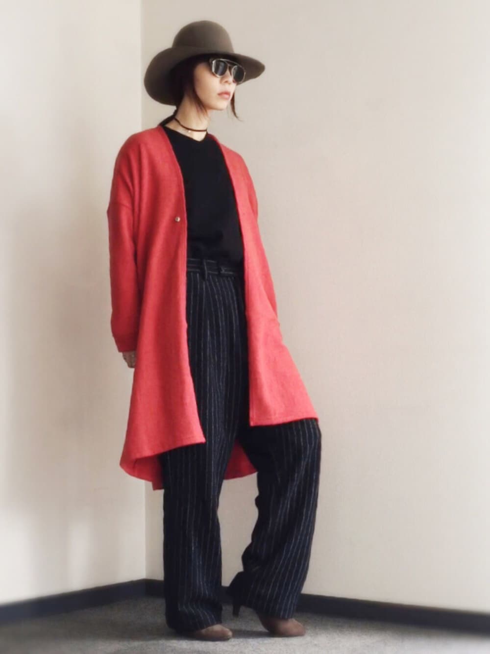 レッド系のカーディガン/ボレロ、ブラック系のニット/セーター、ブルー系のその他パンツを着用したレディースの秋コーディネートの1枚目の写真