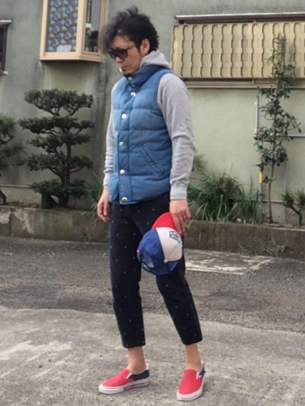 ブルー系のベスト、グレー系のパーカー、ブルー系のパンツを着用したメンズの春コーディネートの1枚目の写真