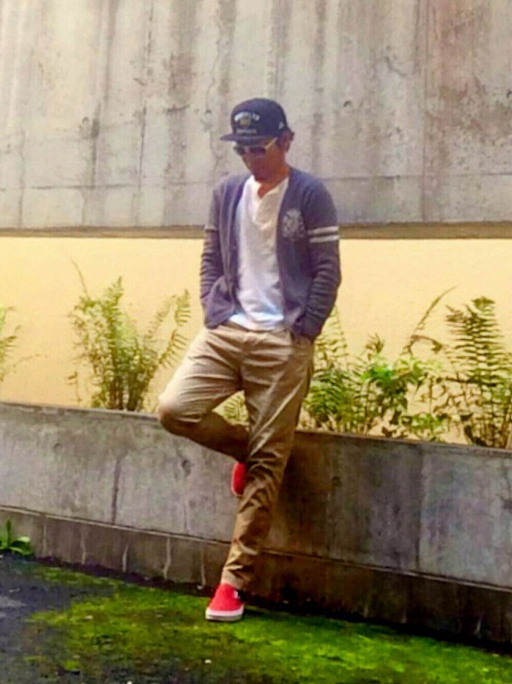 ベージュ系のチノパンツ、ホワイト系のトップス、レッド系のスニーカーを着用したメンズの秋コーディネートの1枚目の写真