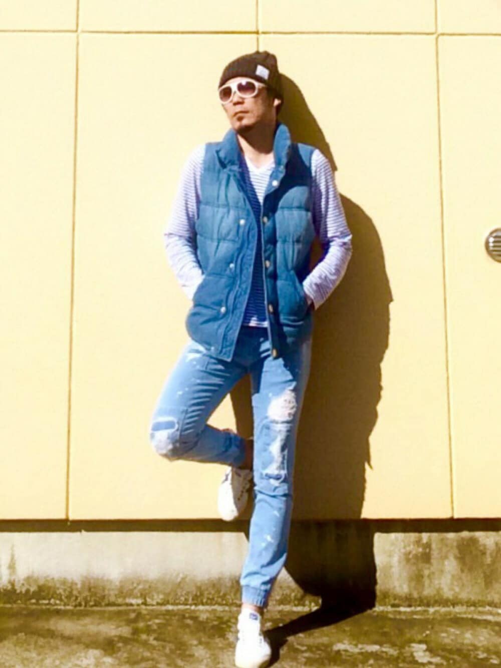 ブルー系のデニムパンツ、ブルー系のベスト、ホワイト系のトップスを着用したメンズの秋コーディネートの1枚目の写真