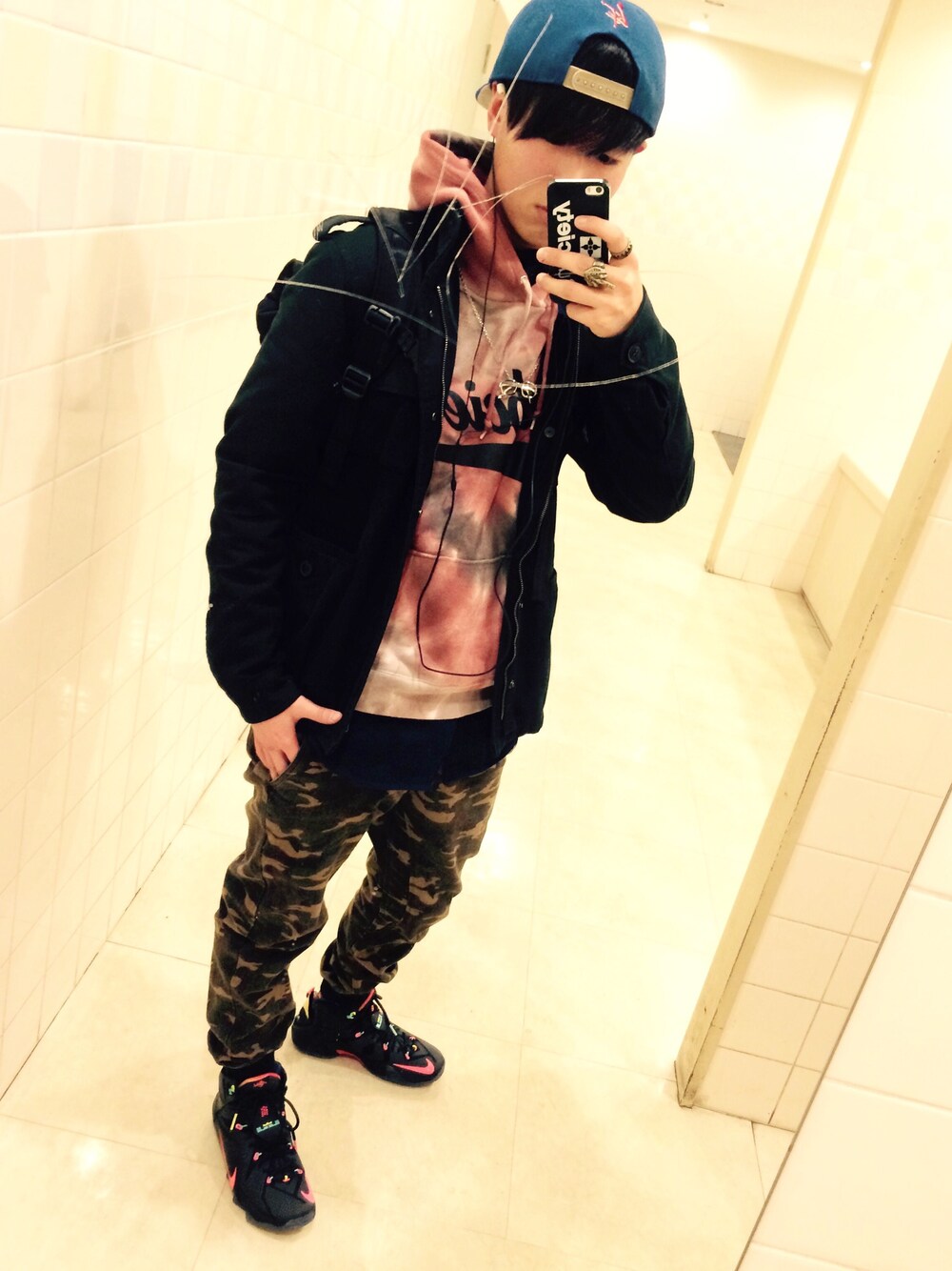 レッド系のパーカー、ブラック系のスニーカー、グリーン系のその他パンツを着用したメンズの冬コーディネートの1枚目の写真