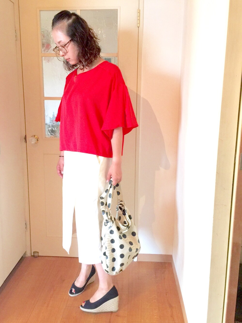 レッド系のシャツ/ブラウス、ホワイト系のトートバッグ、ブラック系のパンプスを着用したレディースの秋コーディネートの1枚目の写真