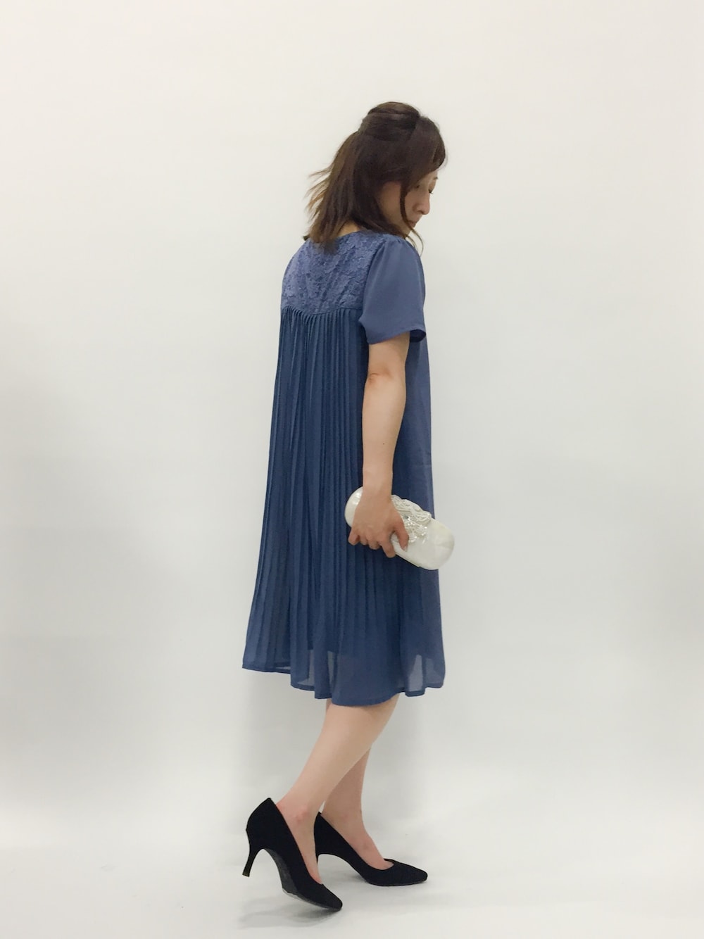 ブルー系のドレス、ホワイト系のクラッチバッグを着用したレディースの春コーディネートの1枚目の写真