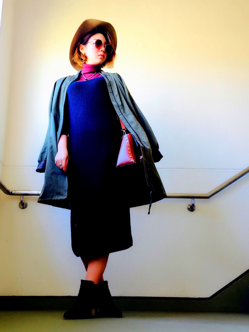 グリーン系のブルゾン、ブラウン系のニット/セーター、ブラック系のワンピースを着用したレディースの秋コーディネートの1枚目の写真