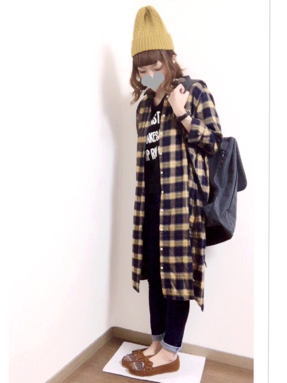 イエロー系のシャツワンピース、ブラウン系のモカシン/デッキシューズ、グレー系のバックパック/リュックを着用したレディースの秋コーディネートの1枚目の写真