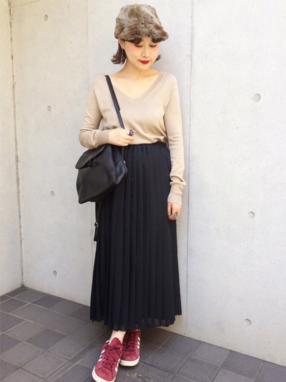 グリーン系のニット/セーター、ブラック系のスカートを着用したレディースの秋コーディネートの1枚目の写真