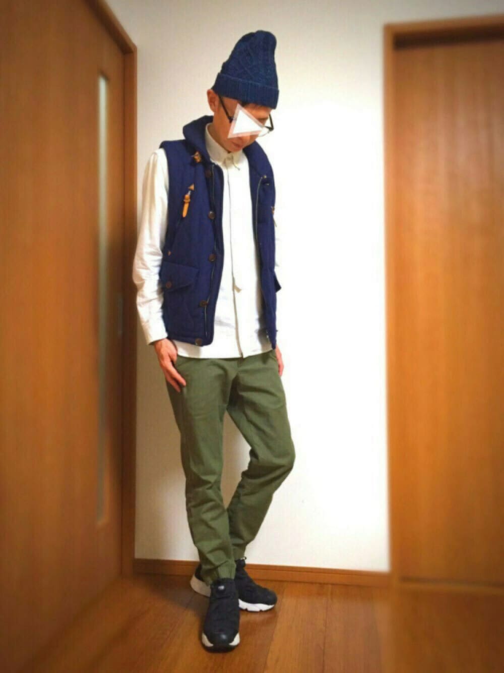 ブルー系のダウンベスト、ホワイト系のシャツ/ブラウス、グリーン系のチノパンツを着用したメンズの秋コーディネートの1枚目の写真