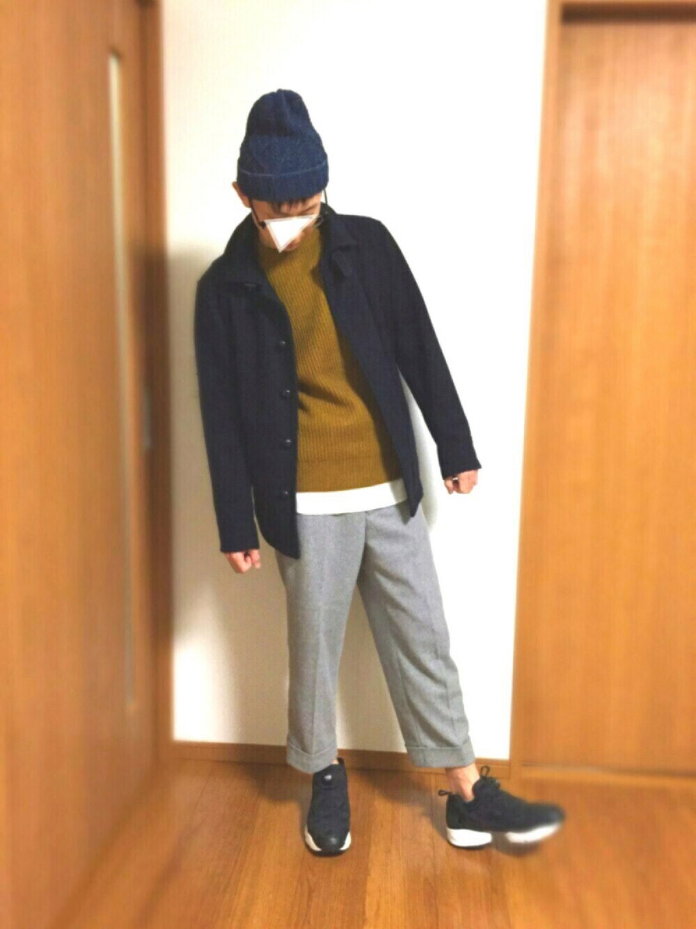 ブラウン系のニット/セーター、ホワイト系のTシャツ/カットソー、ブラック系のスニーカーを着用したメンズの秋コーディネートの1枚目の写真