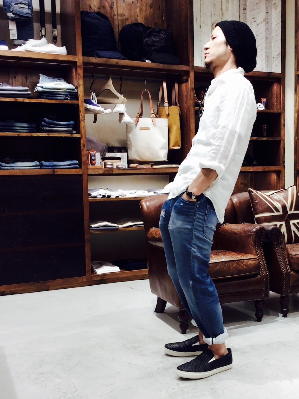 ブルー系のデニムパンツ、ホワイト系のTシャツ/カットソー、ブラック系のスリッポンを着用したメンズの春コーディネートの1枚目の写真