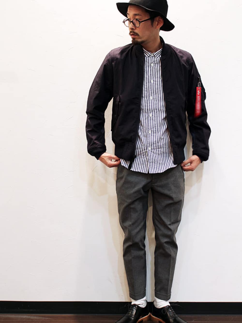 ブルー系のミリタリージャケット、ブルー系のシャツ/ブラウス、グレー系のスラックスを着用したメンズの春コーディネートの1枚目の写真