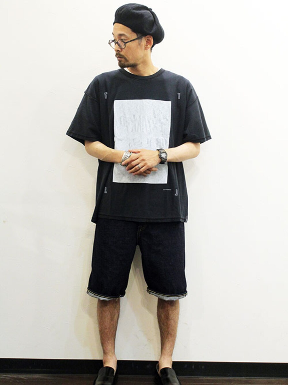 ブラック系のTシャツ/カットソー、ブルー系のデニムパンツ、ブラック系のモカシン/デッキシューズを着用したメンズの夏コーディネートの1枚目の写真