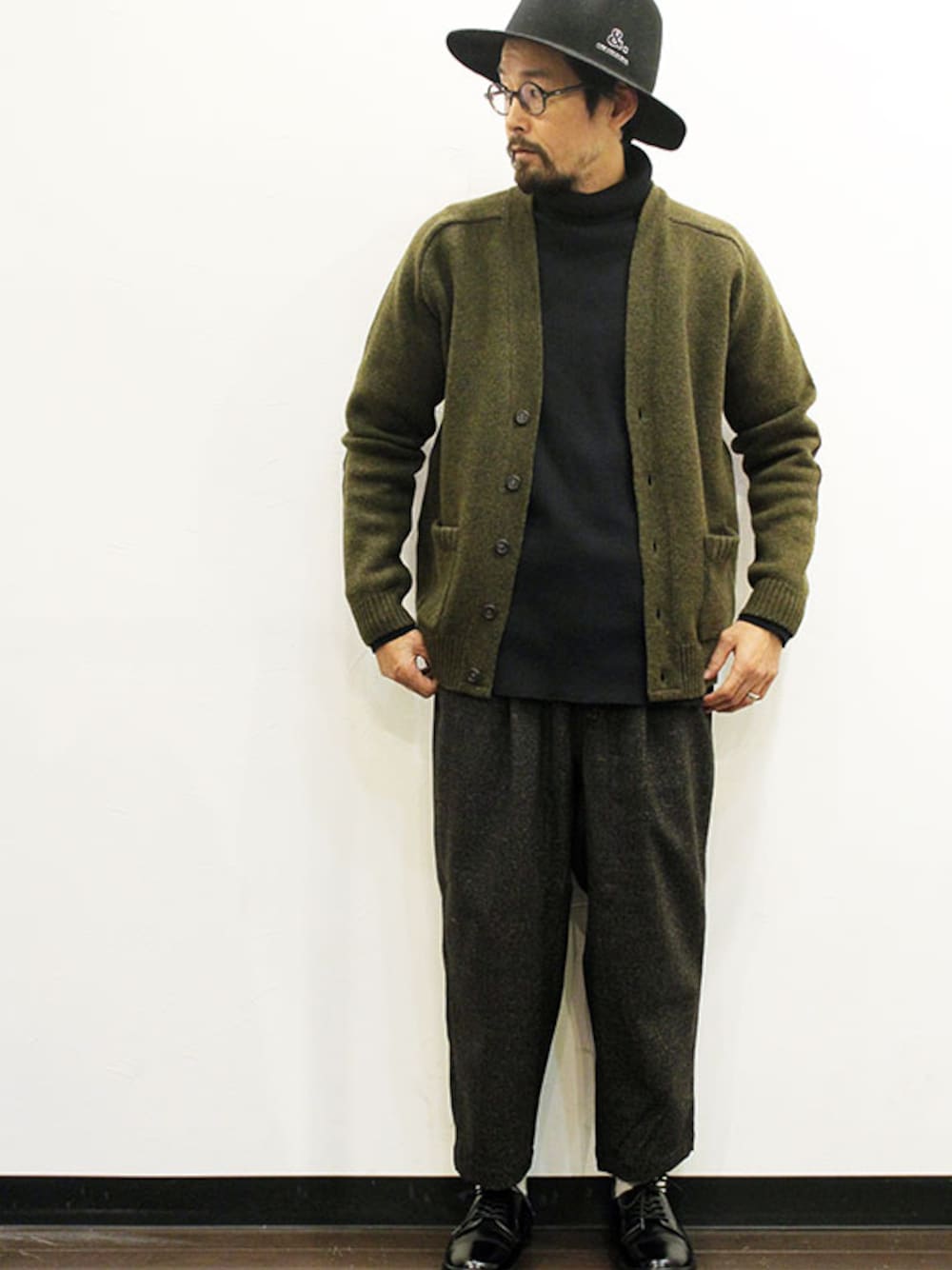 グリーン系のカーディガン/ボレロ、その他のTシャツ/カットソー、ブラック系のスラックスを着用したメンズの秋コーディネートの1枚目の写真