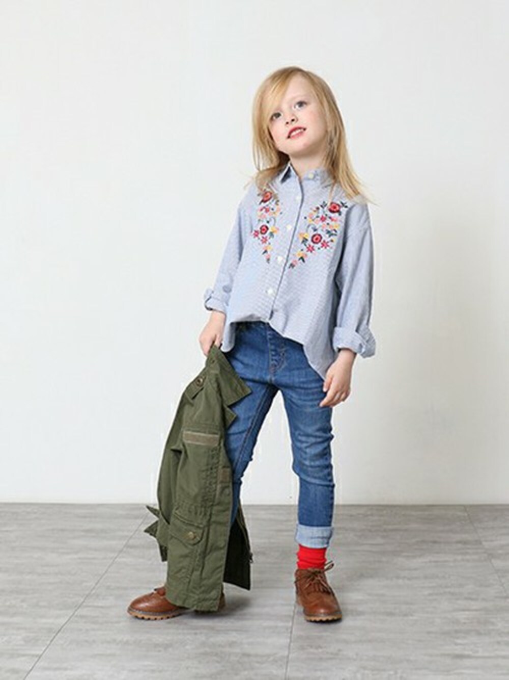 グリーン系のミリタリージャケット、ブルー系のシャツ/ブラウス、ブルー系のデニムパンツを着用したキッズの冬コーディネートの1枚目の写真