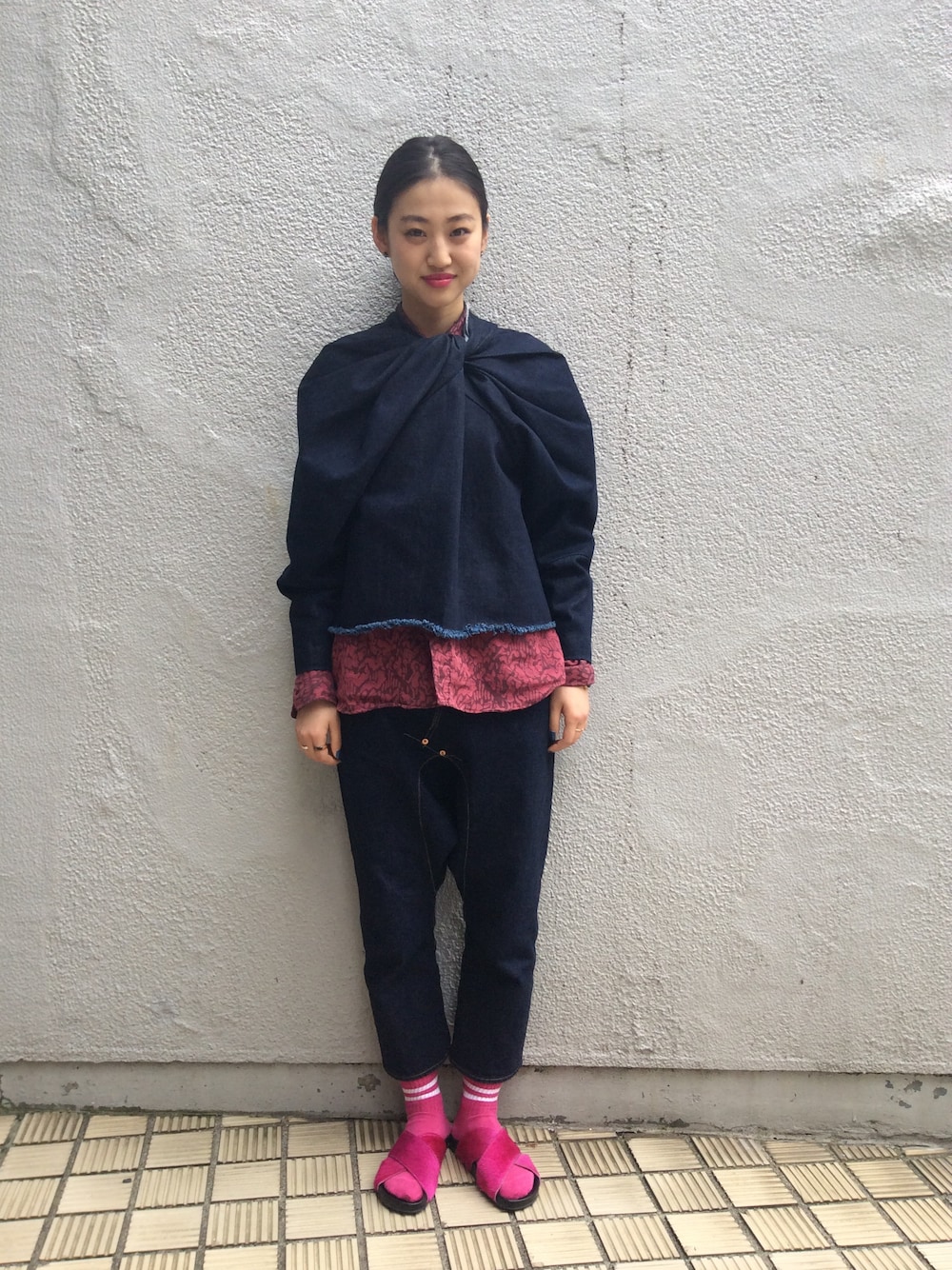 レッド系のサンダル、ブルー系のデニムパンツを着用したレディースの春コーディネートの1枚目の写真