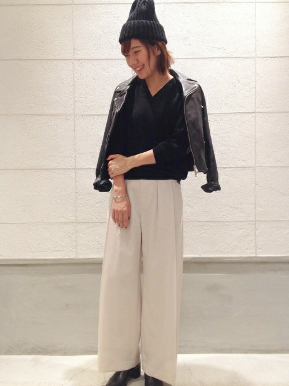 ブラック系のライダースジャケット、ブラック系のニット/セーター、ベージュ系のその他パンツを着用したレディースの秋コーディネートの1枚目の写真