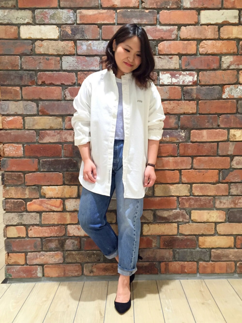 ホワイト系のシャツ/ブラウス、ホワイト系のTシャツ/カットソー、ブルー系のデニムパンツを着用したレディースの春コーディネートの1枚目の写真