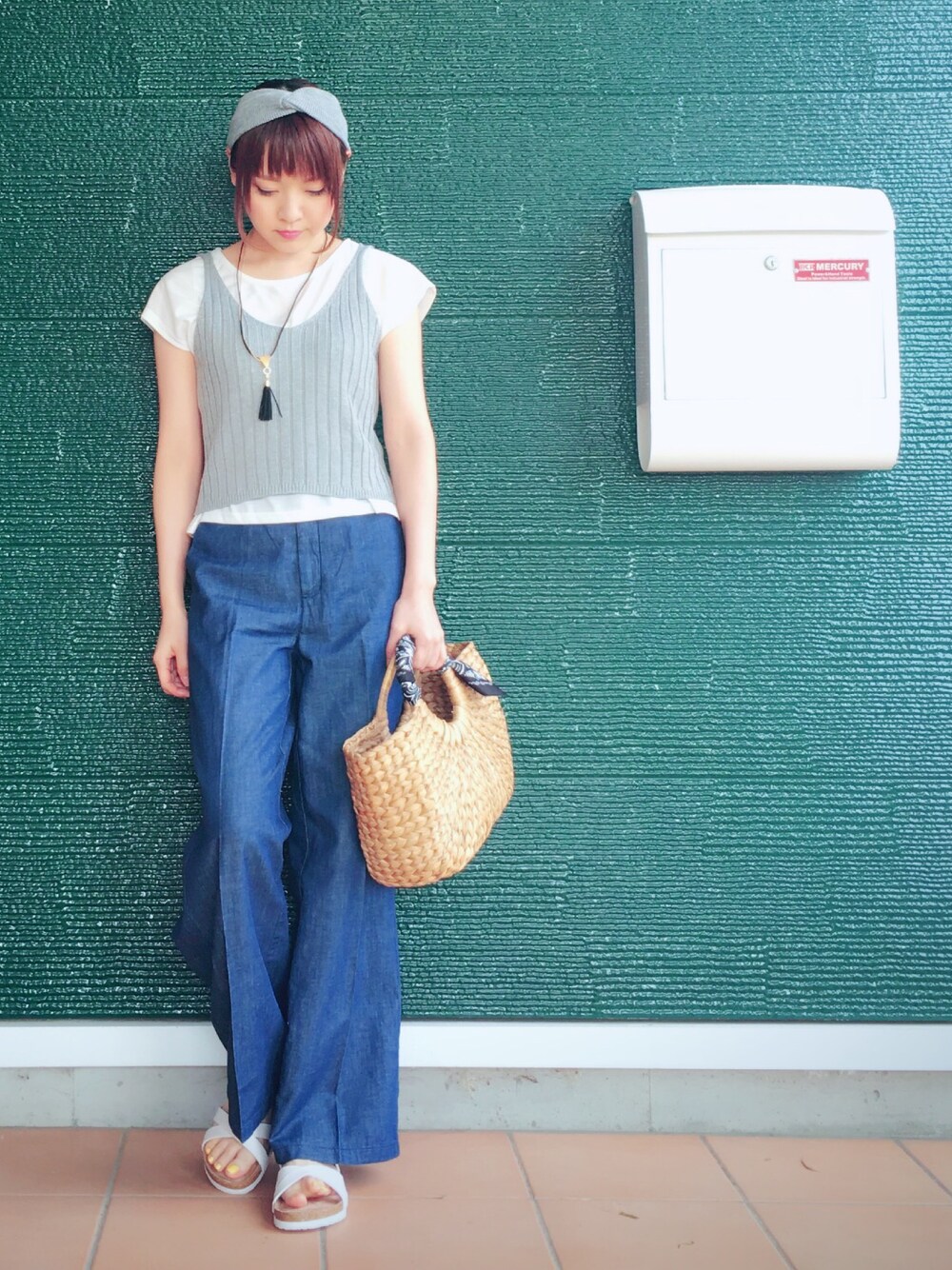 ホワイト系のTシャツ/カットソー、グレー系のニット/セーター、ベージュ系のハンドバッグを着用したレディースの春コーディネートの1枚目の写真