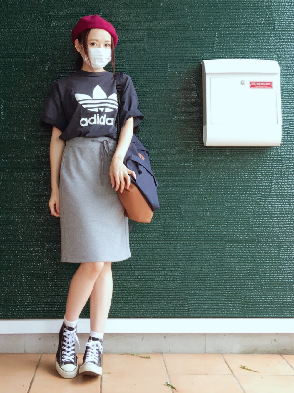 ブルー系のTシャツ/カットソー、ブルー系のバックパック/リュック、グレー系のスカートを着用したレディースの夏コーディネートの1枚目の写真