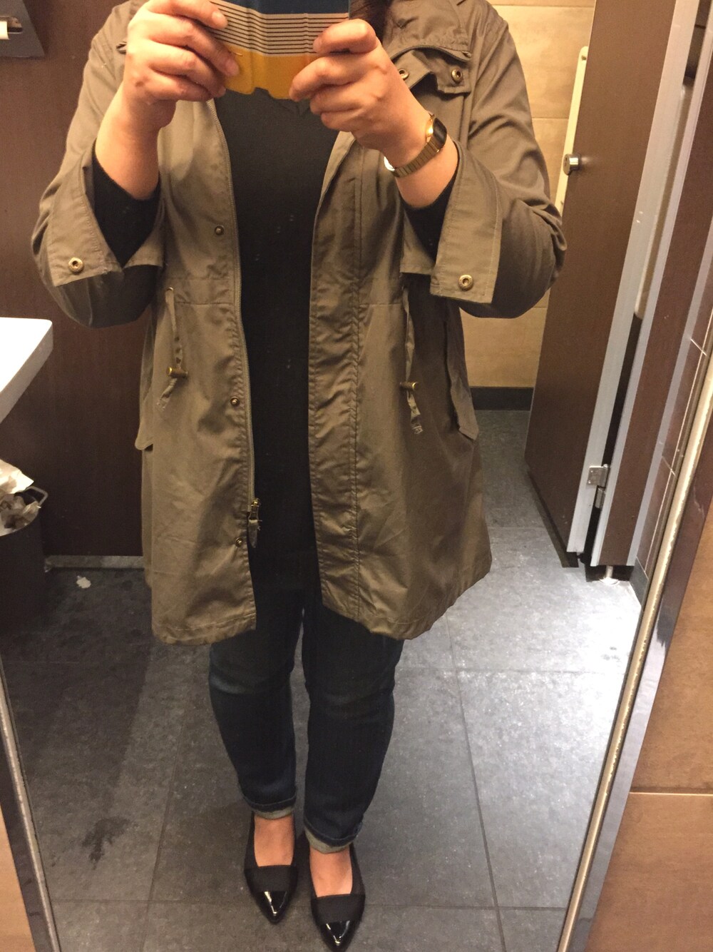 グリーン系のモッズコート、ブルー系のデニムパンツ、ブラック系のパンプスを着用したレディースの春コーディネートの1枚目の写真