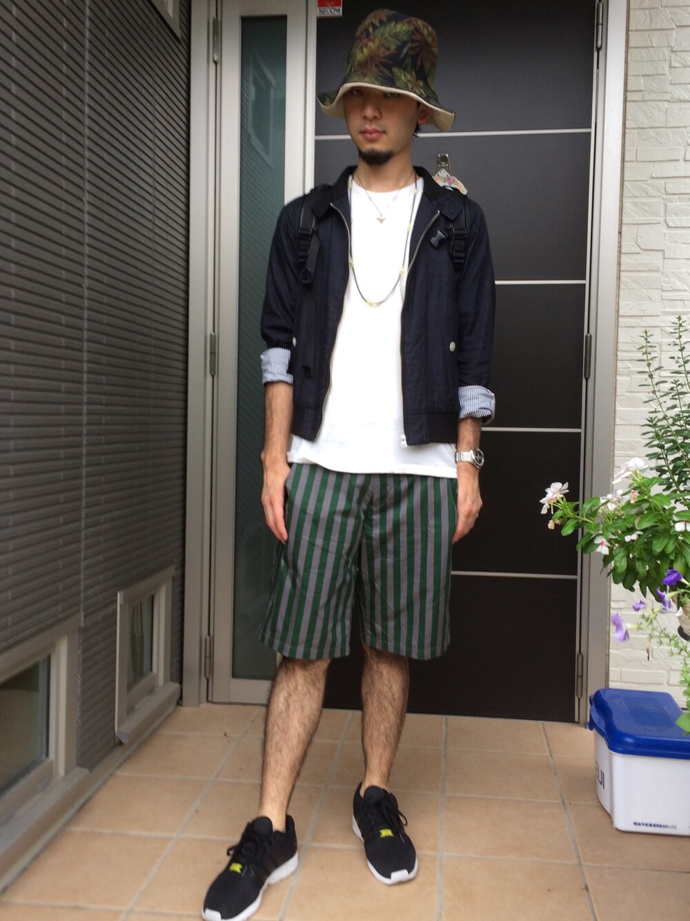 ホワイト系のTシャツ/カットソー、グリーン系のパンツ、ブラック系のスニーカーを着用したメンズの秋コーディネートの1枚目の写真