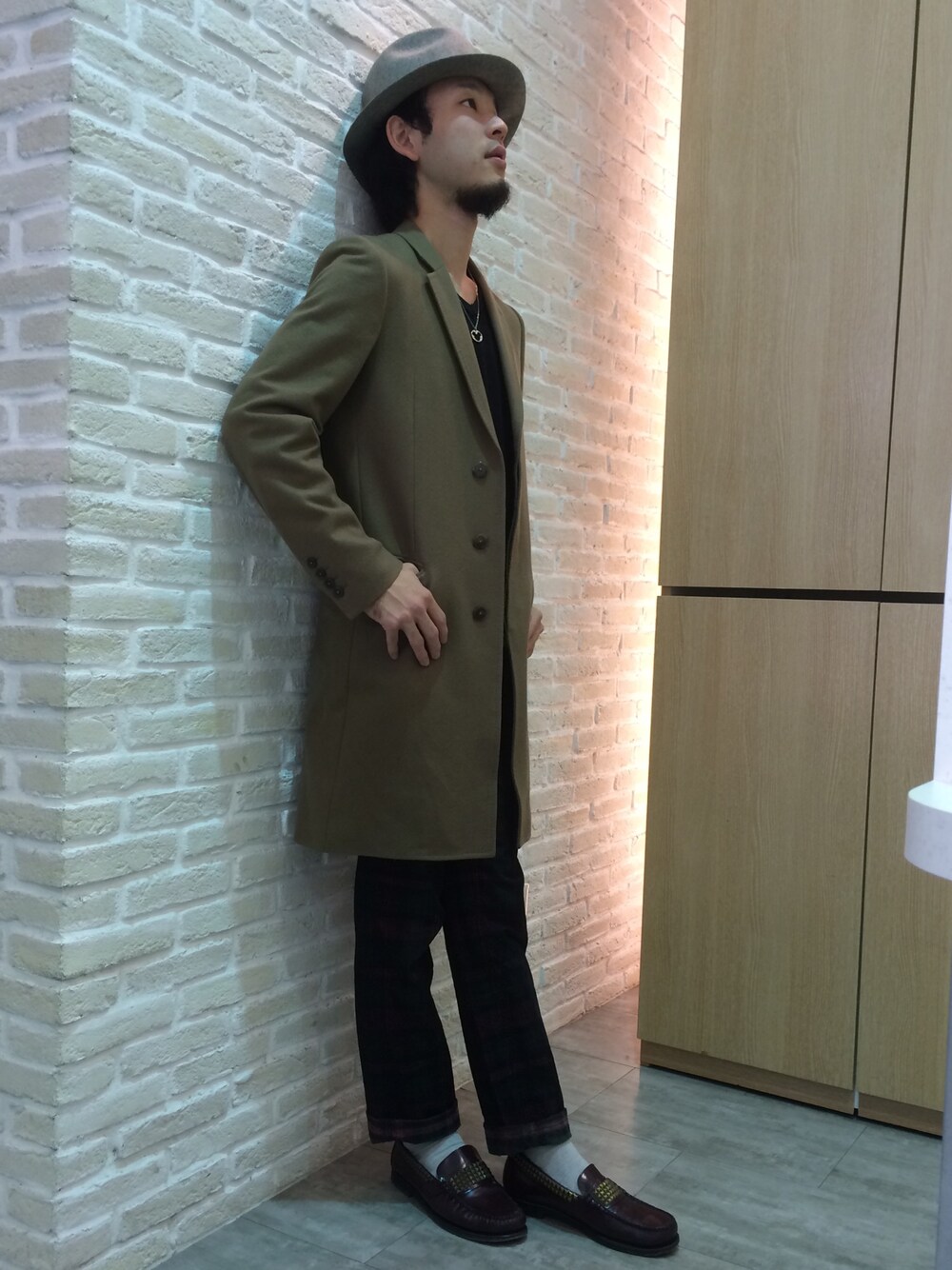ブルー系のニット/セーター、レッド系のその他パンツ、ベージュ系のチェスターコートを着用したメンズの秋コーディネートの1枚目の写真