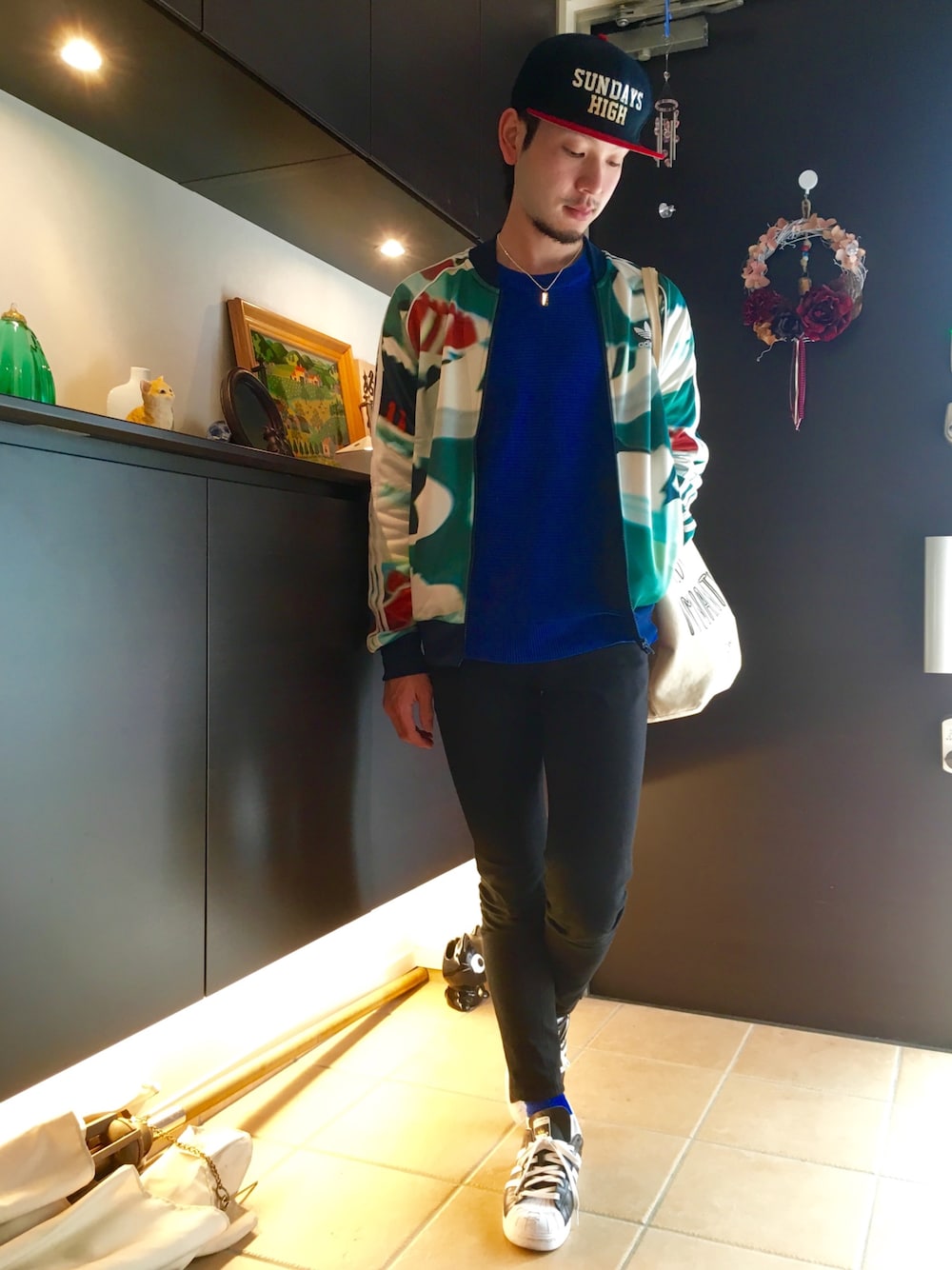 ブルー系のニット/セーター、ブラック系のパンツ、ブラック系のスニーカーを着用したメンズの冬コーディネートの1枚目の写真