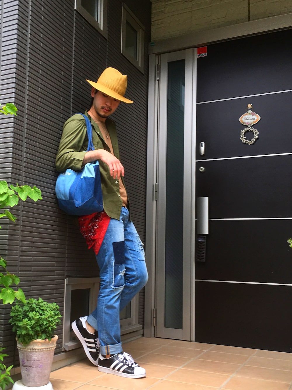 ベージュ系のTシャツ/カットソー、ブルー系のトートバッグ、ブルー系のデニムパンツを着用したメンズの春コーディネートの1枚目の写真