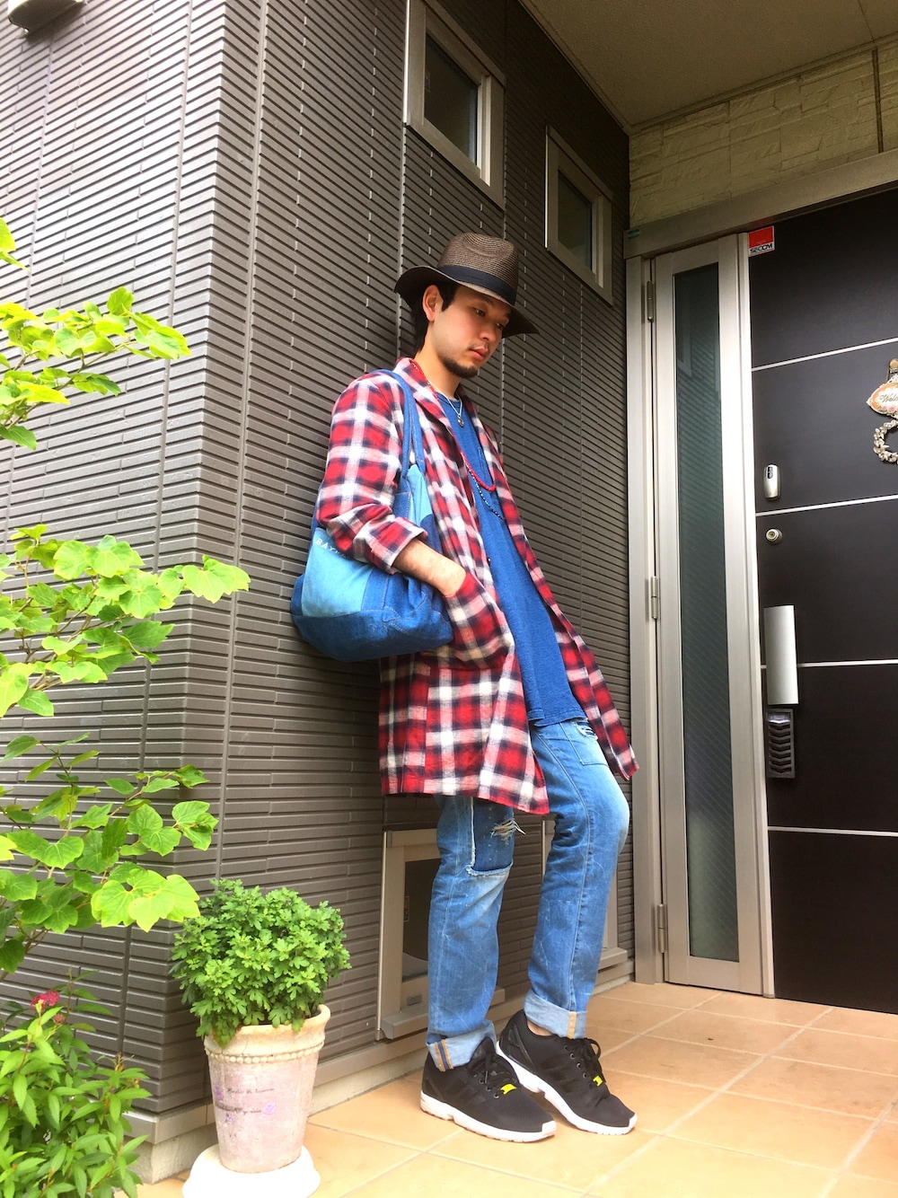 レッド系のその他アウター、ブルー系のデニムパンツ、ブラック系のスニーカーを着用したメンズの春コーディネートの1枚目の写真