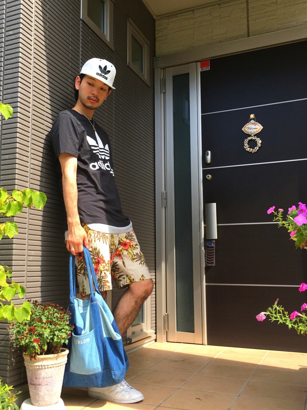 ブラック系のTシャツ/カットソー、ベージュ系のその他パンツ、ブルー系のトートバッグを着用したメンズの夏コーディネートの1枚目の写真