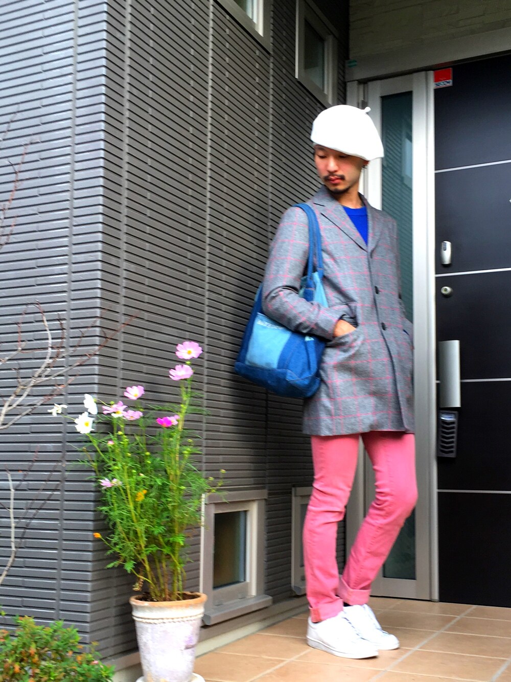 ブルー系のニット/セーター、ピンク系のデニムパンツ、ホワイト系のスニーカーを着用したメンズの秋コーディネートの1枚目の写真