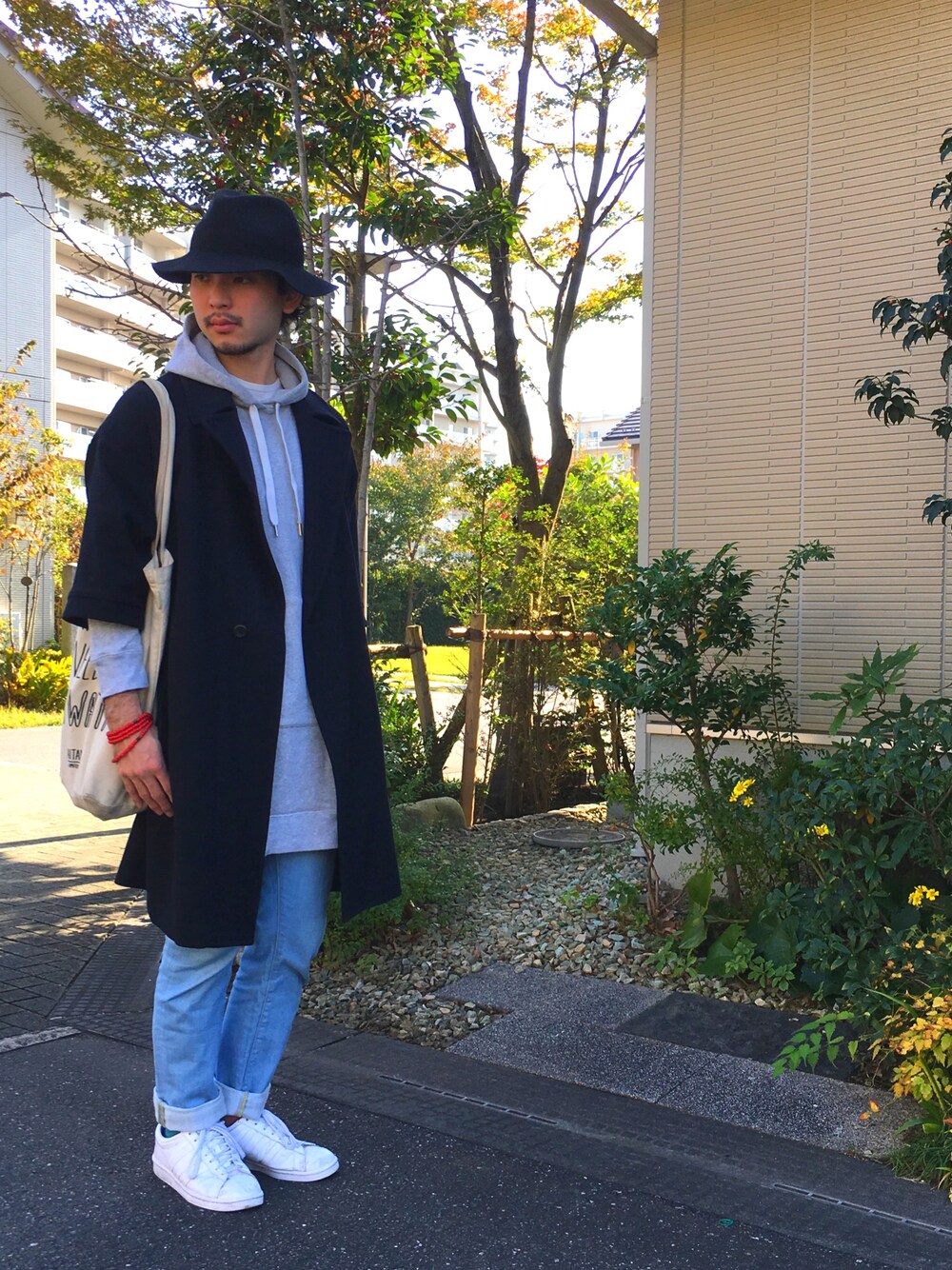 グレー系のワンピース、レッド系のジャケット/アウター、ホワイト系のトートバッグを着用したメンズの秋コーディネートの1枚目の写真