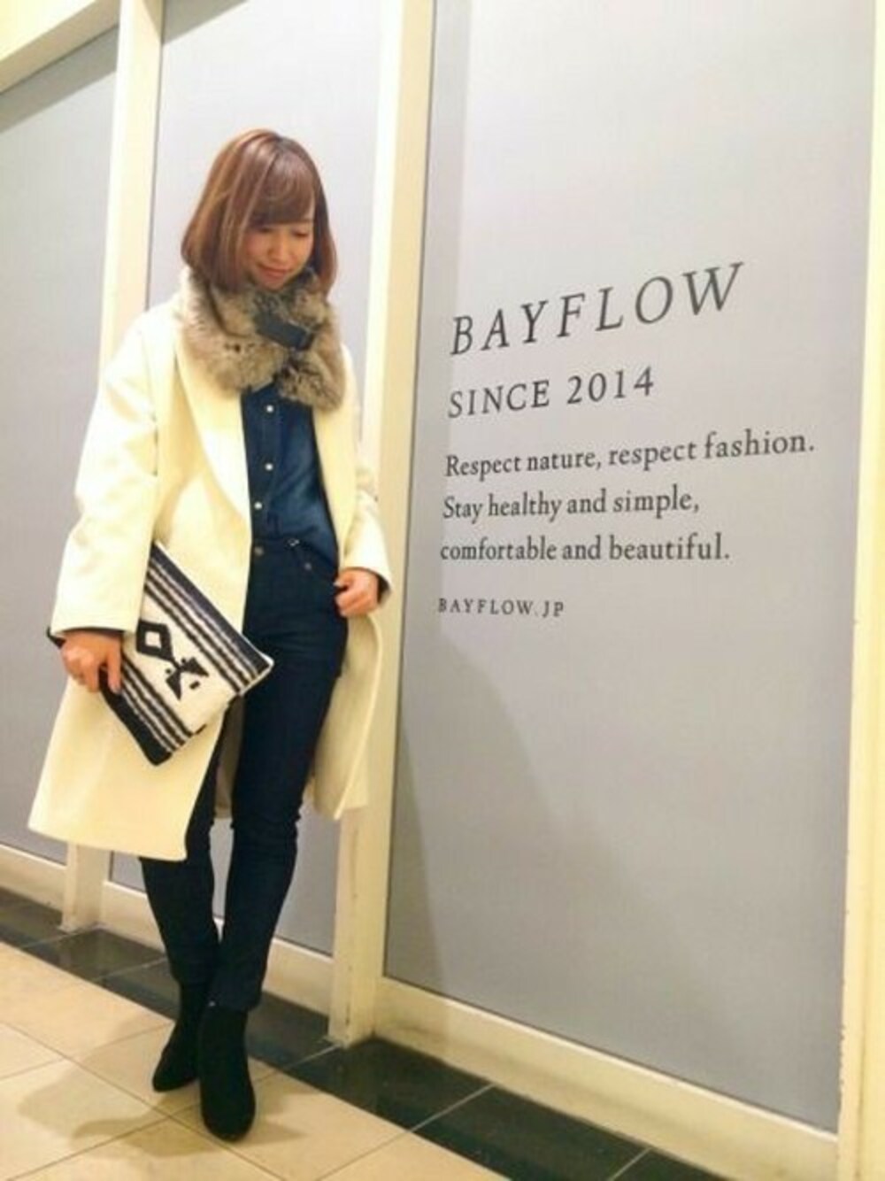 ホワイト系のチェスターコート、ブルー系のシャツ/ブラウス、ブルー系のデニムパンツを着用したレディースの秋コーディネートの1枚目の写真
