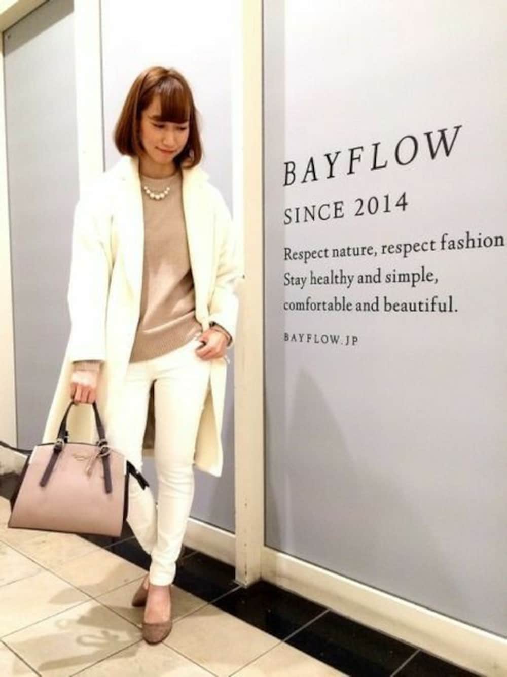 ホワイト系のチェスターコート、ベージュ系のニット/セーター、ホワイト系のデニムパンツを着用したレディースの冬コーディネートの1枚目の写真