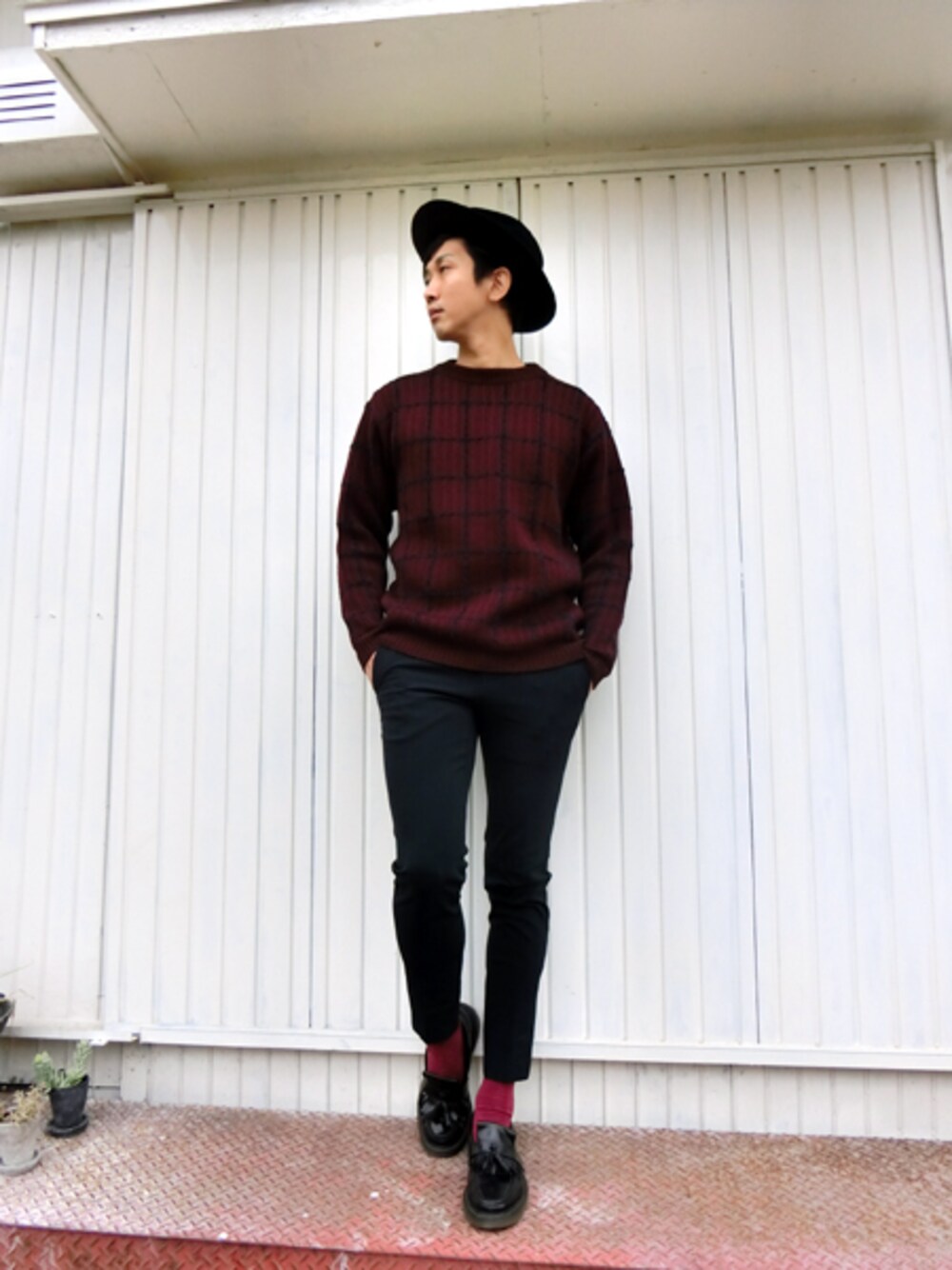 オレンジ系のニット/セーター、ブルー系のスラックスを着用したメンズの秋コーディネートの1枚目の写真