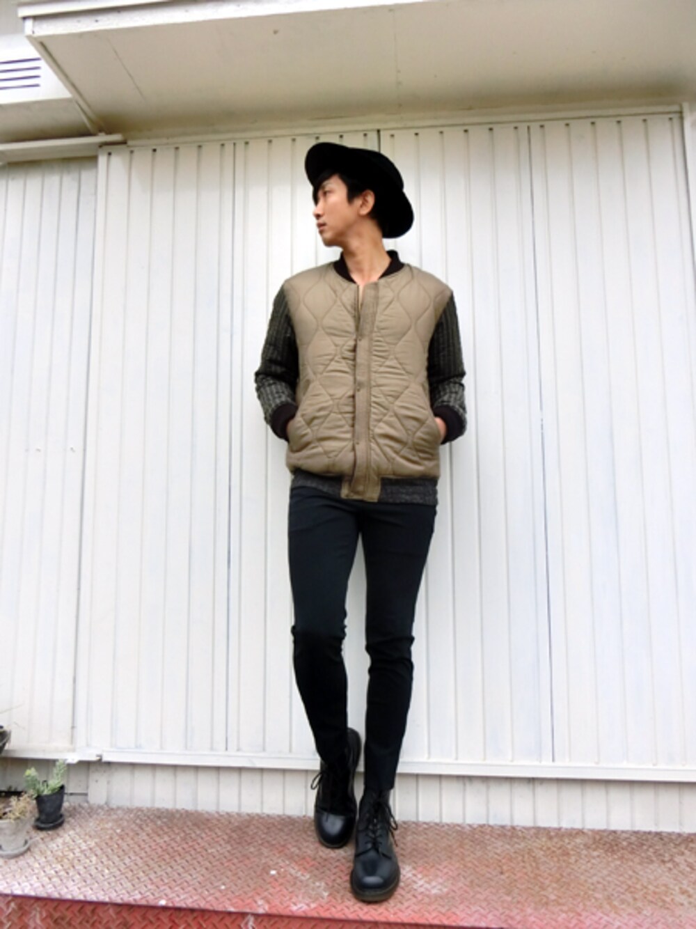 ブラウン系のミリタリージャケット、ブルー系のスラックス、ブルー系のブーツを着用したメンズの秋コーディネートの1枚目の写真