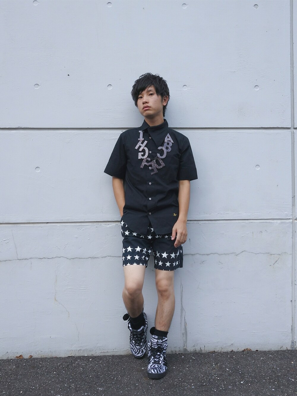 ブラック系のスニーカー、グレー系のアクセサリーを着用したメンズの夏コーディネートの1枚目の写真