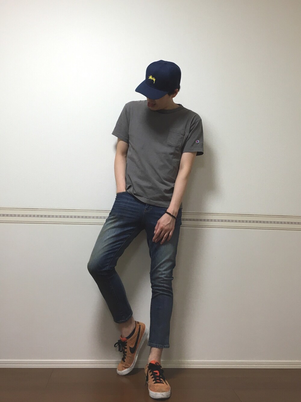 オレンジ系のスニーカー、ブルー系のデニムパンツを着用したメンズの夏コーディネートの1枚目の写真