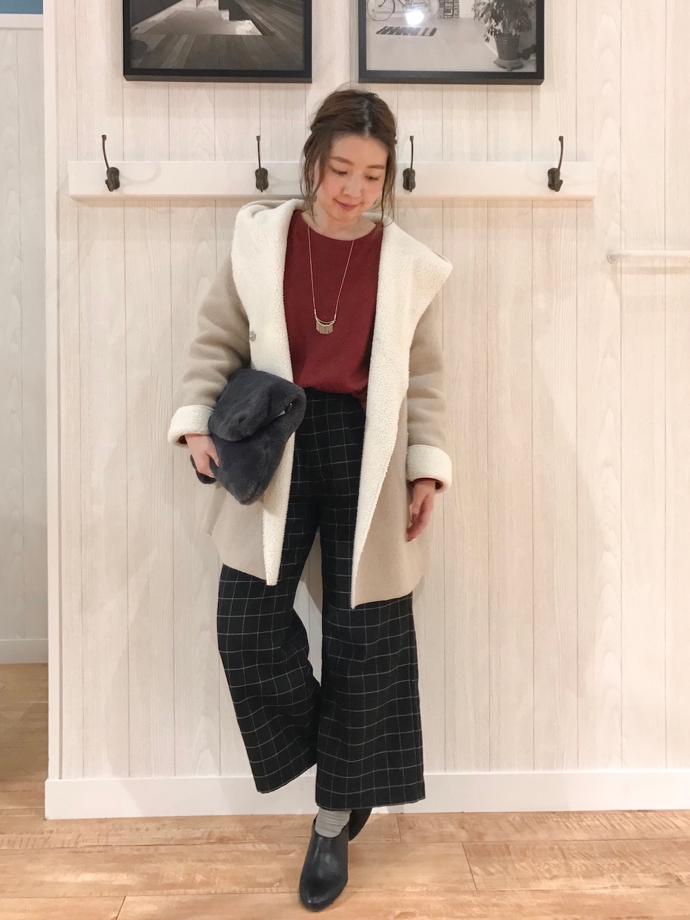 レッド系のニット/セーター、ベージュ系のその他アウター、ブラック系のその他パンツを着用したレディースの秋コーディネートの1枚目の写真