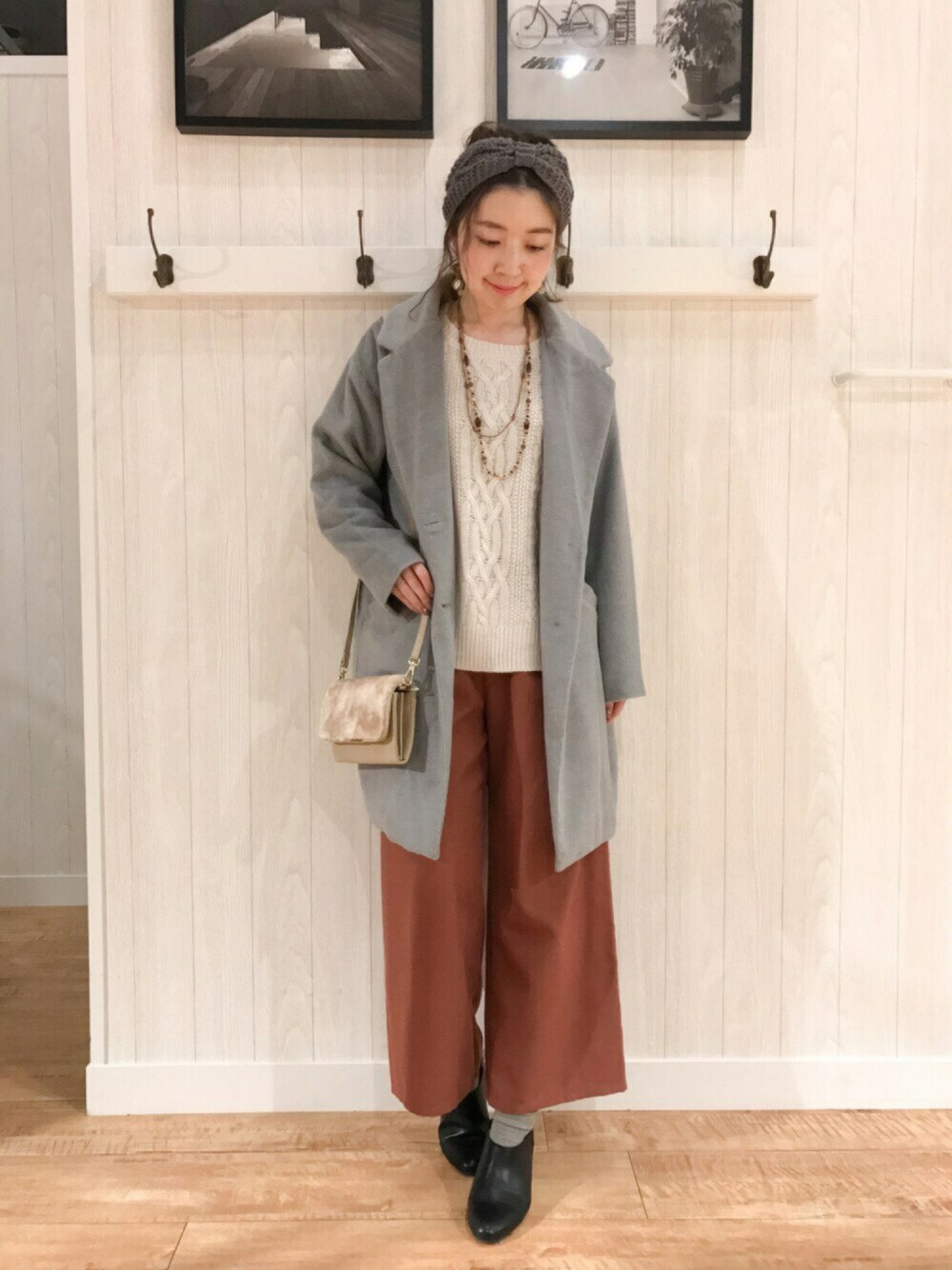 グレー系のチェスターコート、ホワイト系のニット/セーター、レッド系のその他パンツを着用したレディースの秋コーディネートの1枚目の写真