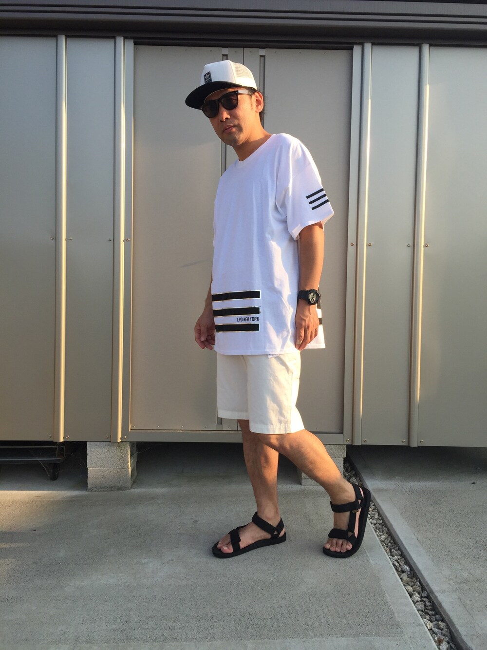 ホワイト系のTシャツ/カットソー、ホワイト系のその他パンツ、ブラック系のサンダルを着用したメンズの夏コーディネートの1枚目の写真