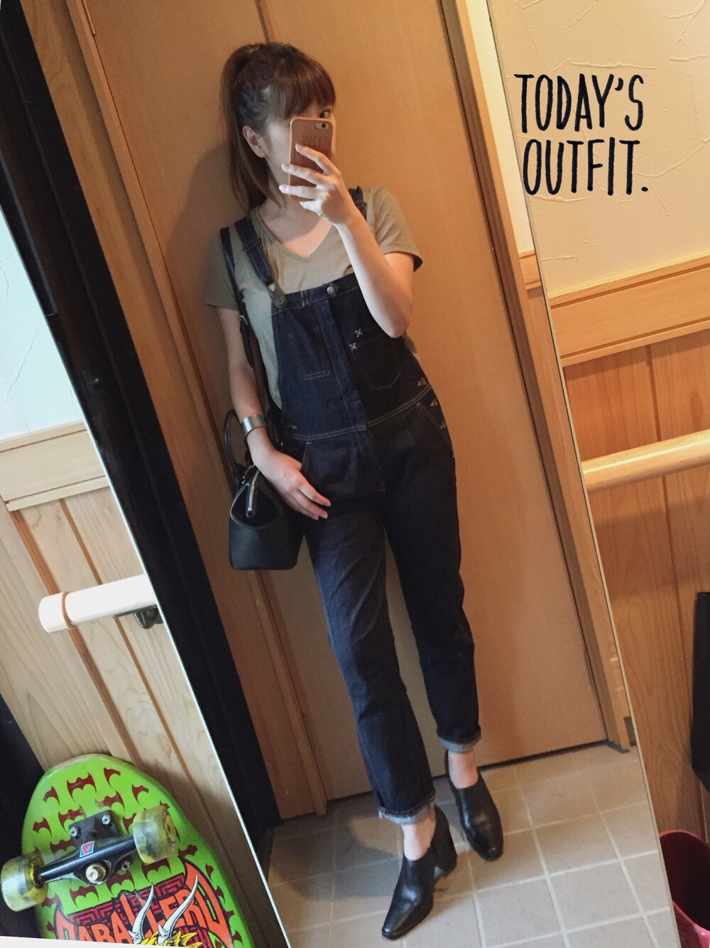 ブルー系のサロペット/オーバーオール、グリーン系のTシャツ/カットソー、ブラック系のショルダーバッグを着用したレディースの秋コーディネートの1枚目の写真