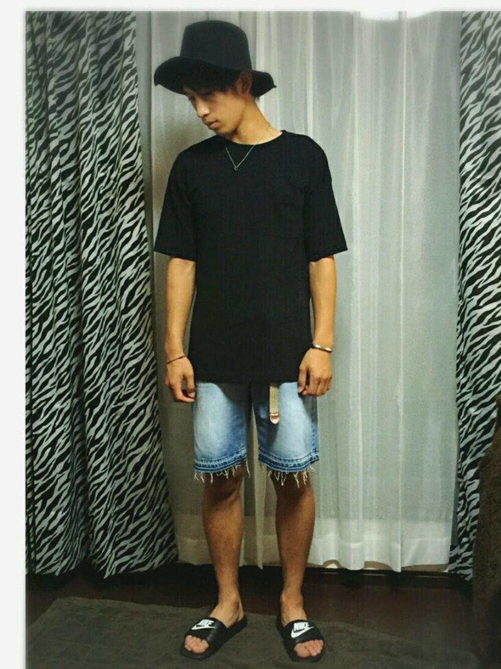 ブラック系のTシャツ/カットソー、ブルー系のデニムパンツ、ブラック系のサンダルを着用したメンズの夏コーディネートの1枚目の写真