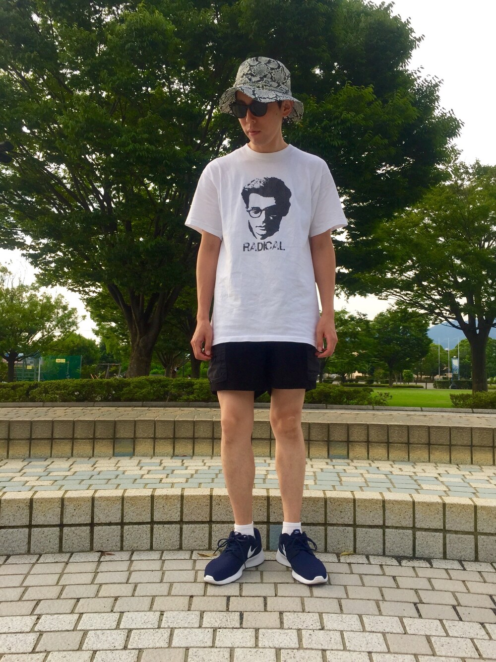 ホワイト系のTシャツ/カットソー、ブラック系のその他パンツ、ブルー系のスニーカーを着用したメンズの夏コーディネートの1枚目の写真