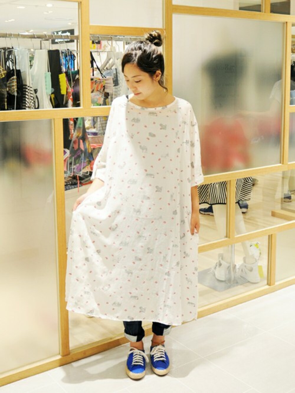 ブルー系のデニムパンツ、ホワイト系のワンピース、ブルー系のスニーカーを着用したレディースの夏コーディネートの1枚目の写真