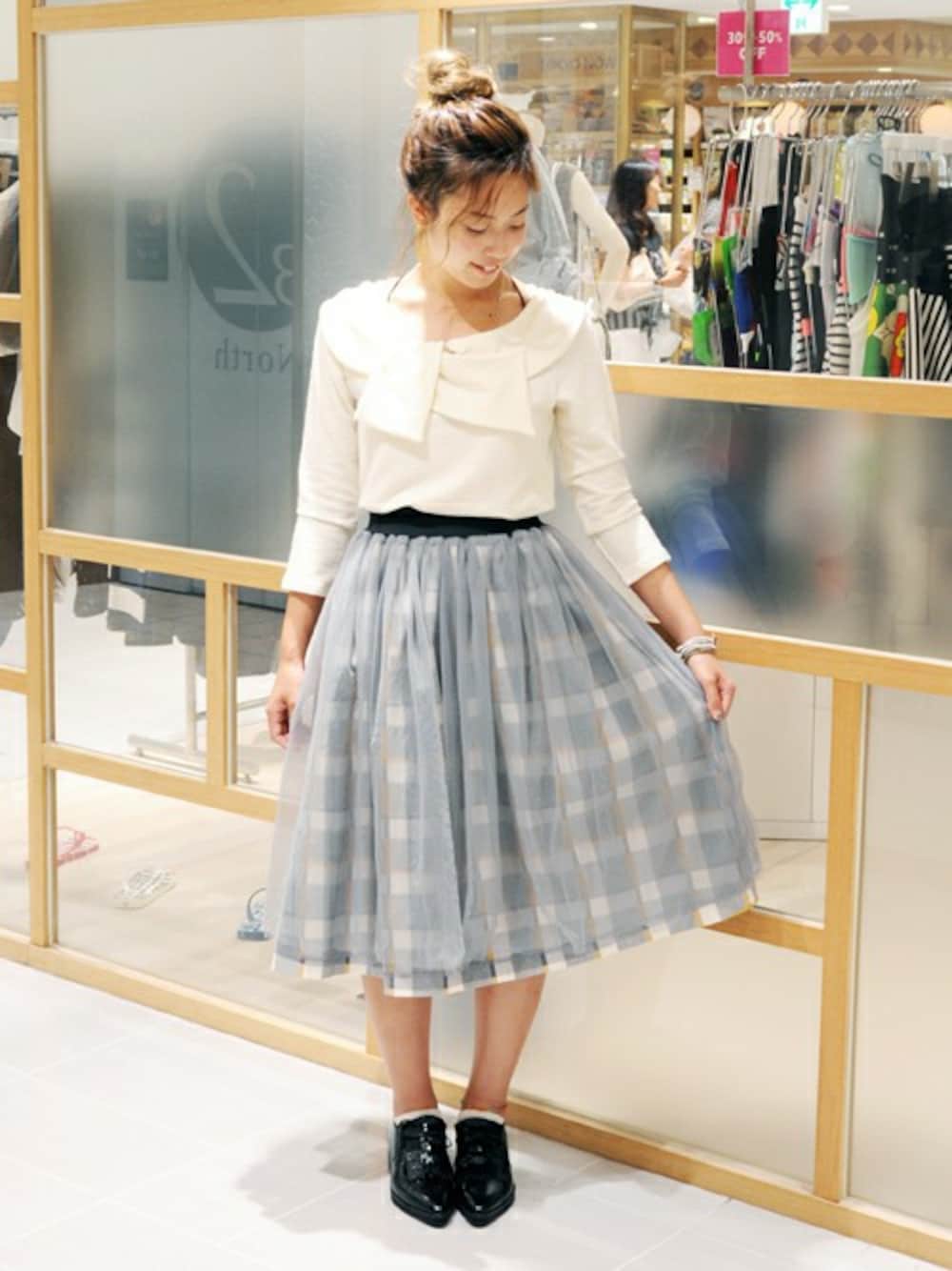 グレー系のスカート、ホワイト系のTシャツ/カットソーを着用したレディースの夏コーディネートの1枚目の写真