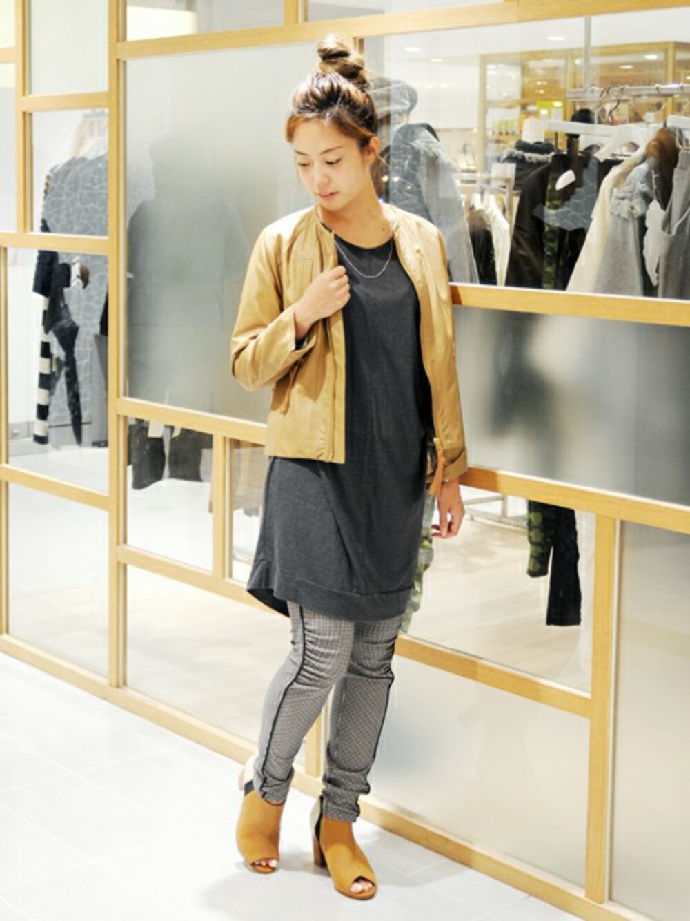 ブラウン系のブルゾン、グレー系のチュニック、ベージュ系のその他パンツを着用したレディースの秋コーディネートの1枚目の写真