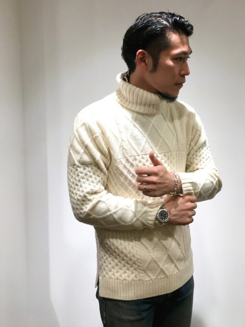ホワイト系のニット/セーター、ブルー系のデニムパンツ、シルバー系のブレスレットを着用したメンズの秋コーディネートの1枚目の写真