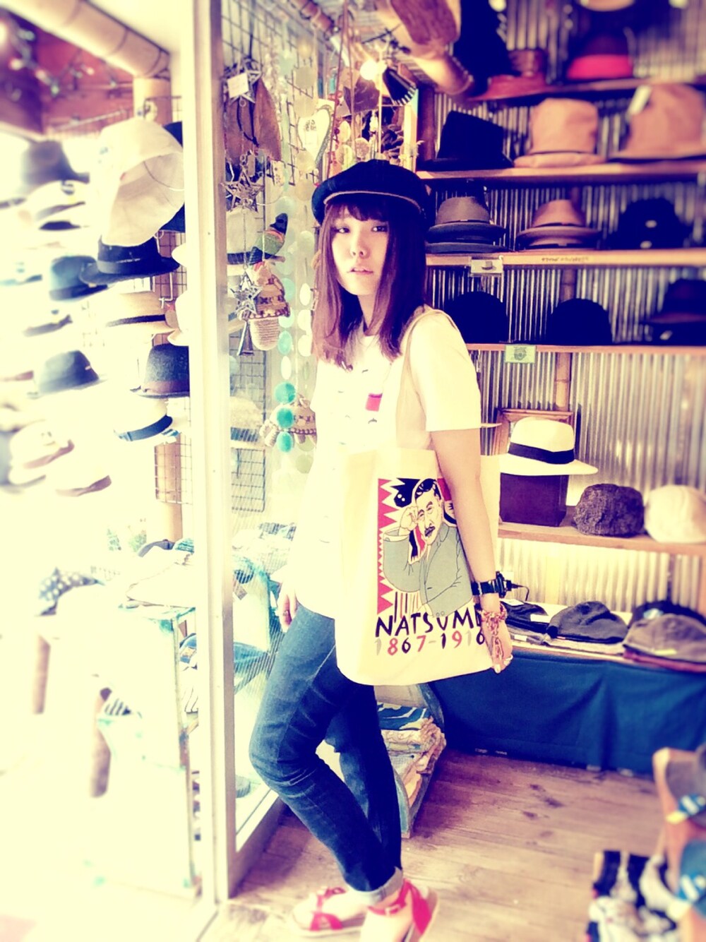 ホワイト系のトートバッグ、ブルー系のデニムパンツ、レッド系のサンダルを着用したレディースの春コーディネートの1枚目の写真