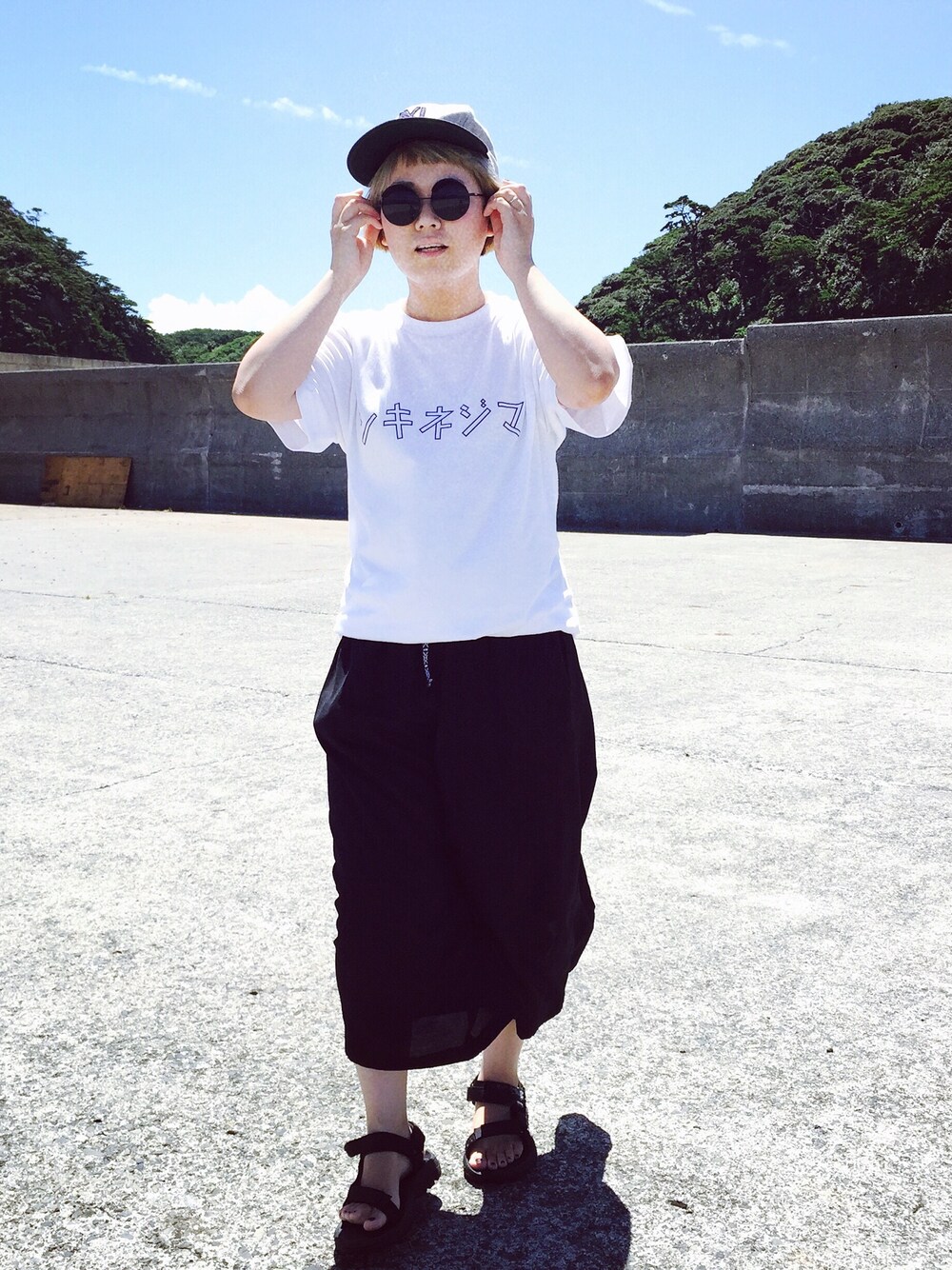 ブラック系のパンツを着用したレディースの夏コーディネートの1枚目の写真