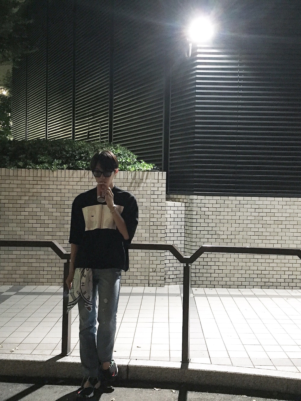 ブラック系のTシャツ/カットソー、ブルー系のデニムパンツ、ブラック系のスニーカーを着用したメンズの夏コーディネートの1枚目の写真